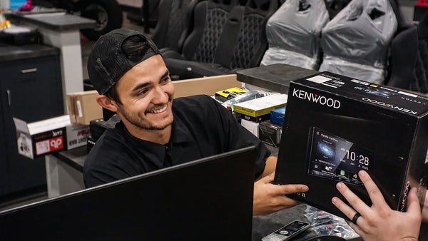 Salesman handing Kenwood head unit to Customer